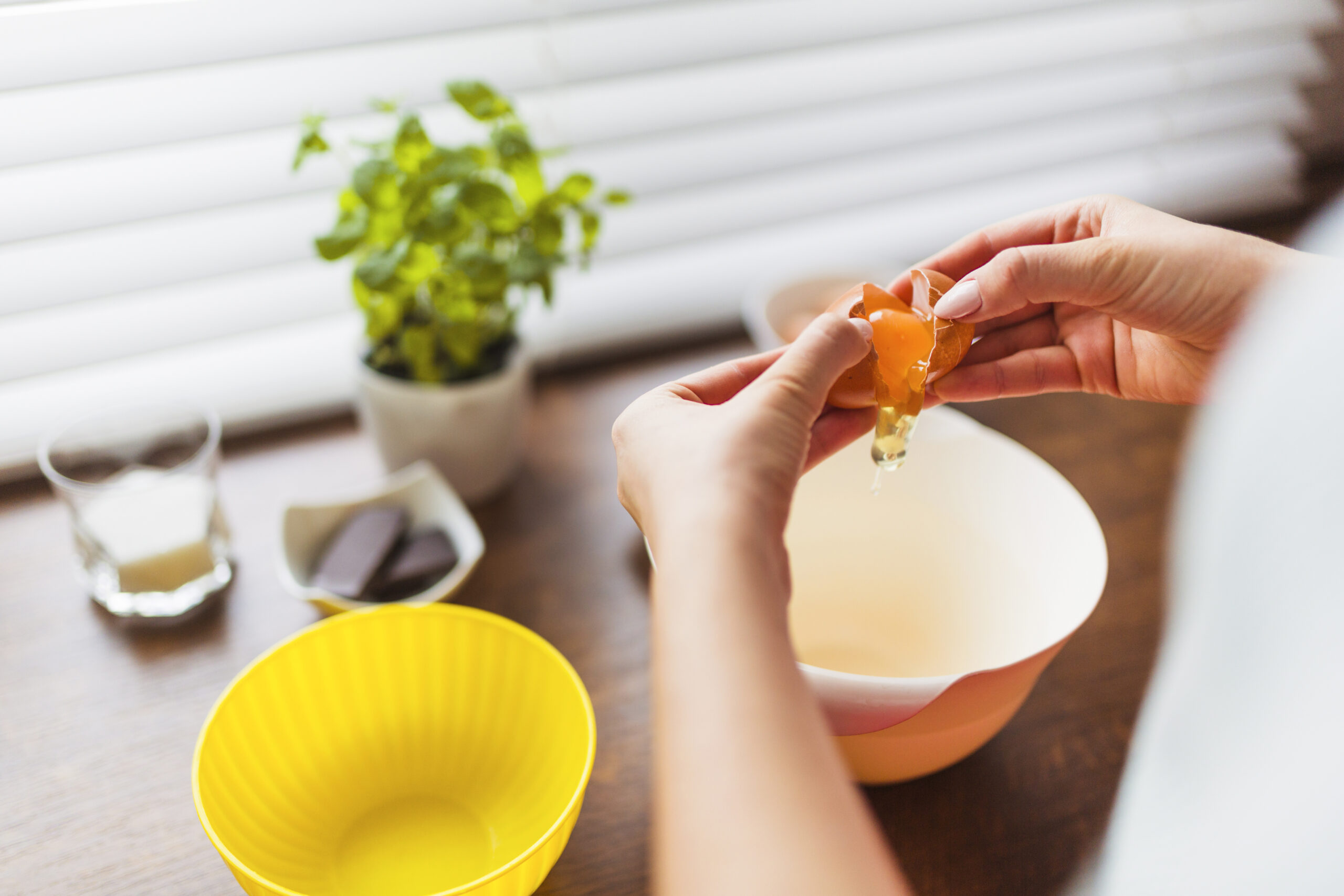 crop woman pouring egg into bowl scaled